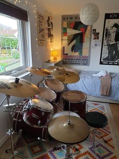 a bedroom with a drum set in front of a window