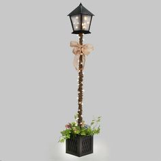 a lamp post with lights on it and flowers in the planter next to it