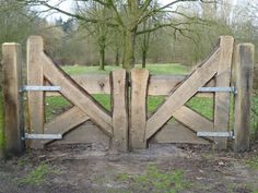 a wooden gate in the middle of a field