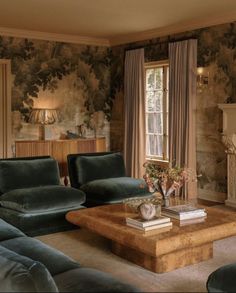 a living room filled with furniture and walls covered in floral wallpaper, along with a fire place