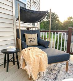 a porch with a chair, table and rug on it