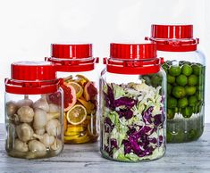 four glass jars filled with different types of vegetables