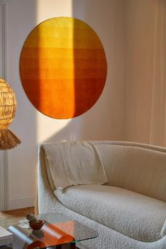 a living room filled with furniture and a round light fixture