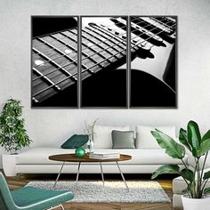 three black and white guitars hanging in a living room