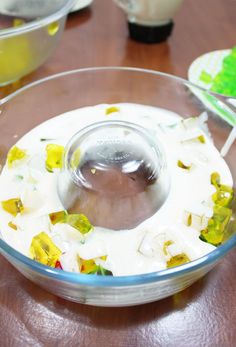 a glass bowl filled with food on top of a wooden table