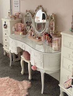 a white vanity with lots of drawers and mirrors on it's sides in a pink room