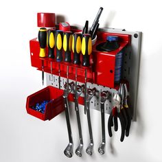 there is a red tool rack with tools hanging on it's side and other tools attached to the wall