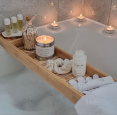 a bathtub with candles, soaps and other personal care items sitting on it