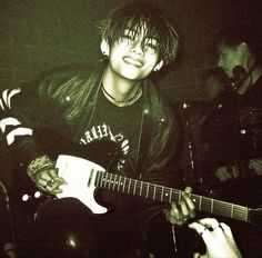 a young man is playing an electric guitar