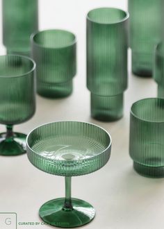 many green glass cups and saucers on a table