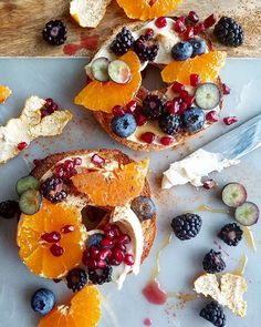 an assortment of fruit and bread on a cutting board