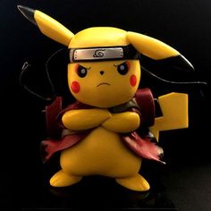 a pikachu figurine is posed on a black surface with its arms crossed