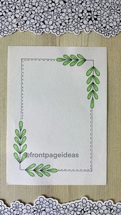 a piece of paper with green leaves on it next to some doily and lace