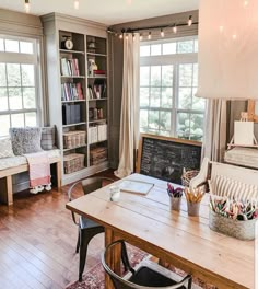 a living room filled with furniture and a chalkboard on the wall next to a window