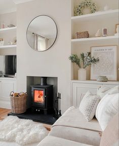 a living room filled with furniture and a fire place next to a mirror on the wall