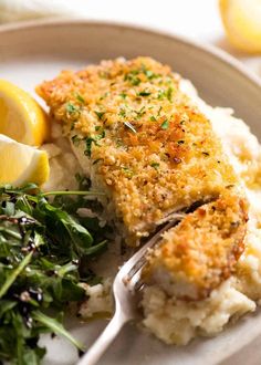 a white plate topped with fish and mashed potatoes