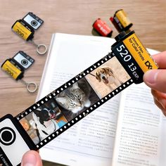 a person holding up a film strip with pictures on it next to several camera clips