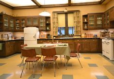 a kitchen with a table and chairs in front of an oven, refrigerator and stove