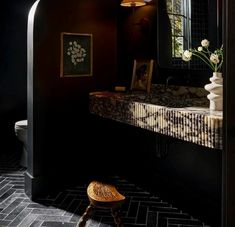 a bathroom with a sink, mirror and stool