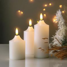 three lit candles sitting on top of a table