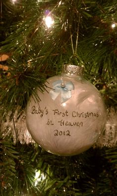 a baby's first christmas ornament hanging from a tree