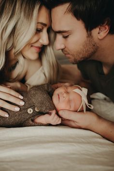 a man and woman holding a baby in their arms