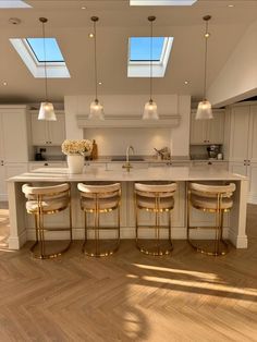 a large kitchen with an island and four stools in front of the counter top