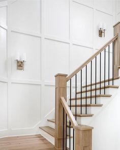 a staircase with white walls and wood handrails