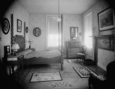 an old fashioned bedroom with antique furniture and pictures on the wall, along with carpeted flooring