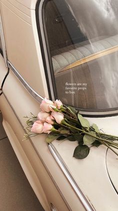 flowers are placed on the window sill of an old car