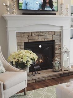 a living room with a fire place and a television on the fireplace mantels