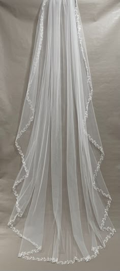 the back of a white veil with flowers on it