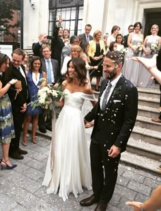 the bride and groom are walking down the steps with confetti thrown on them