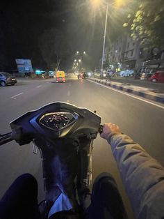 a person riding a motorcycle down a street at night