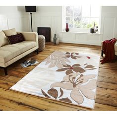 a living room filled with furniture and a rug on top of a hard wood floor