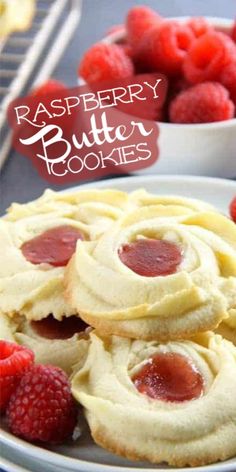 raspberry butter cookies on a plate with fresh raspberries in the background