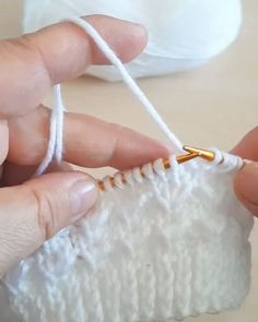 someone is knitting something white on the table