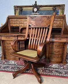 an old wooden desk with a chair in front of it and a mirror on the wall