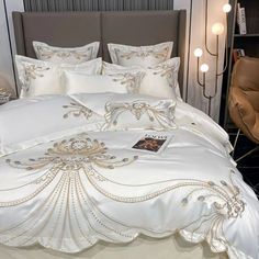 a bed with white and gold comforters on it