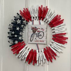 a red, white and blue wreath made out of clothes pins is hanging on the door