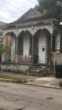 an old run down house with porches and balconies on the front door