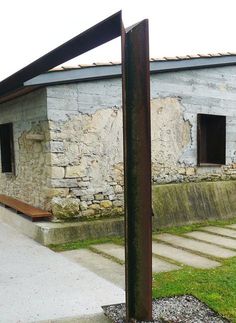 an old stone building with steps leading up to it and a wooden bench in the foreground