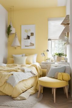 a bedroom with yellow walls and white bedding in the corner, along with two chairs