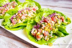 three lettuce cups filled with salad on top of a white plate