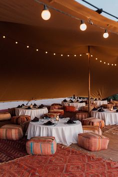 tables and chairs are set up in a tent for an outdoor dinner or banquet event