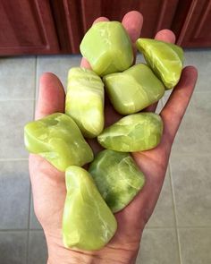 a person holding some green rocks in their hand