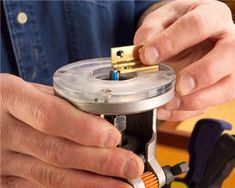 a man is working on something with a small device in his hand and some tools around him