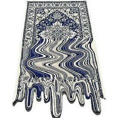 a blue and white area rug with an intricate design on the bottom, in front of a