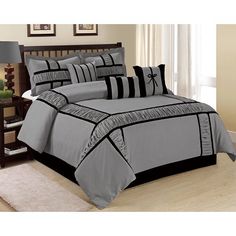 a bed with grey and black comforters in a room