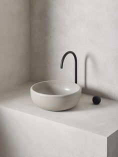 a white sink sitting on top of a counter next to a black faucet